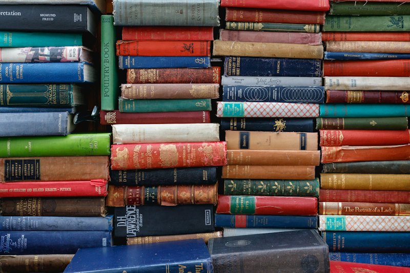 A wall of old clothbound books stacked in coloured rows