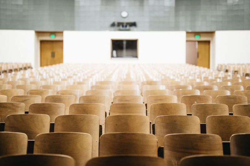 Rows of desks set out in an examination hall