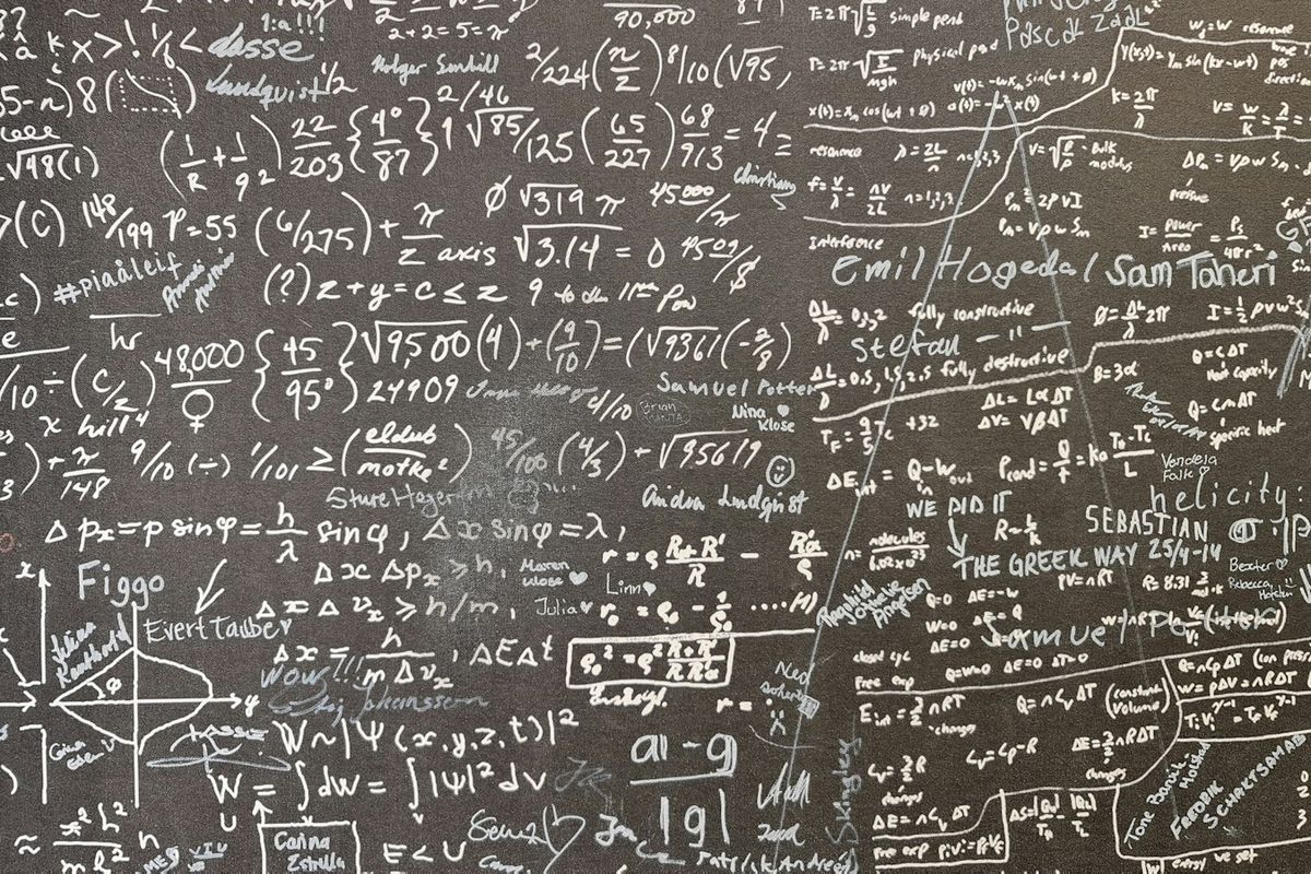 A blackboard covered edge to edge in handwritten mathematical equations