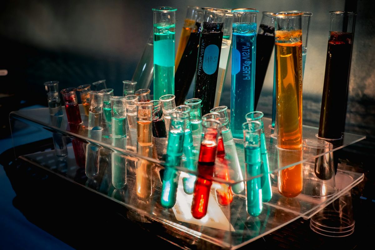 A rack of laboratory test tubes filled with coloured liquids